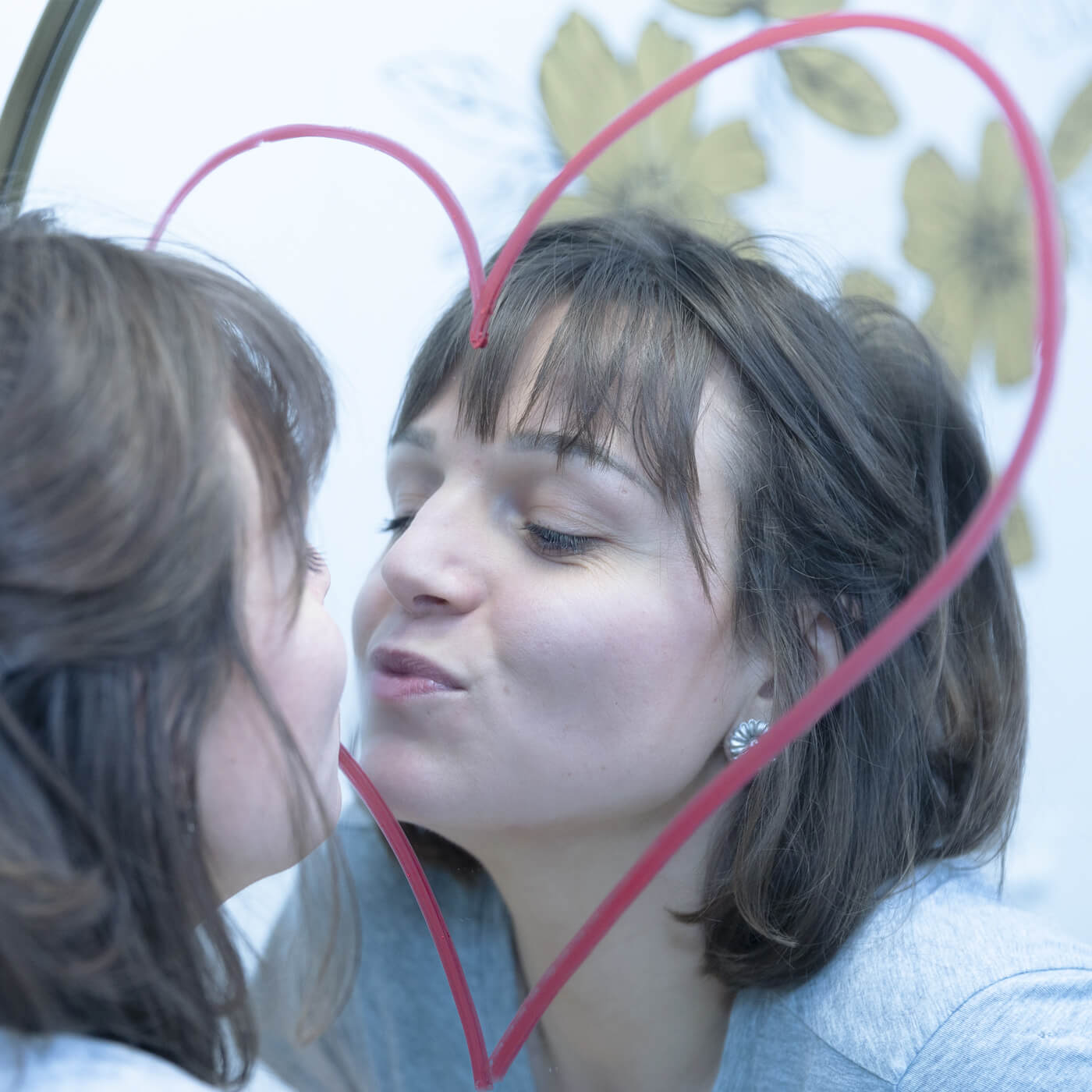 femme embrasse miroir avec un coeur sur le miroir
